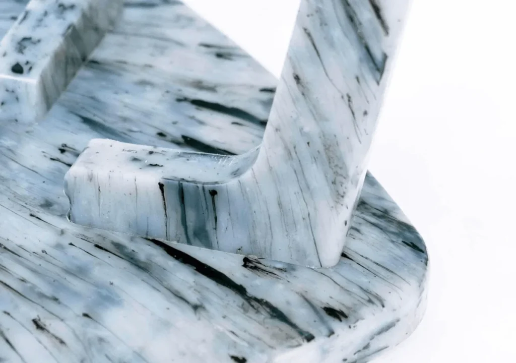 Close-up of a marbled, blue-and-white object with smooth, curved edges and a polished surface—an elegant symbol of corporate social responsibility—set against a plain white background.