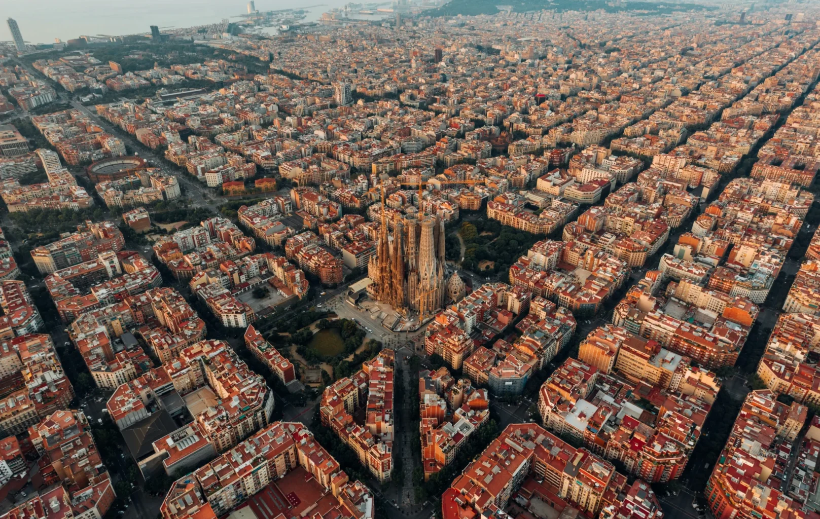 Vista aèria d'una ciutat amb una gran catedral al centre, envoltada per una quadrícula d'edificis de color ataronjat vermellós densament agrupats.